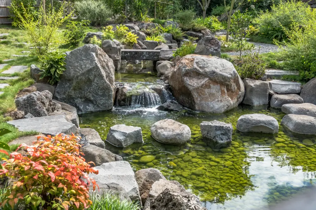 Japanischer Gartenteich mit Natursteinen und Wasserfall